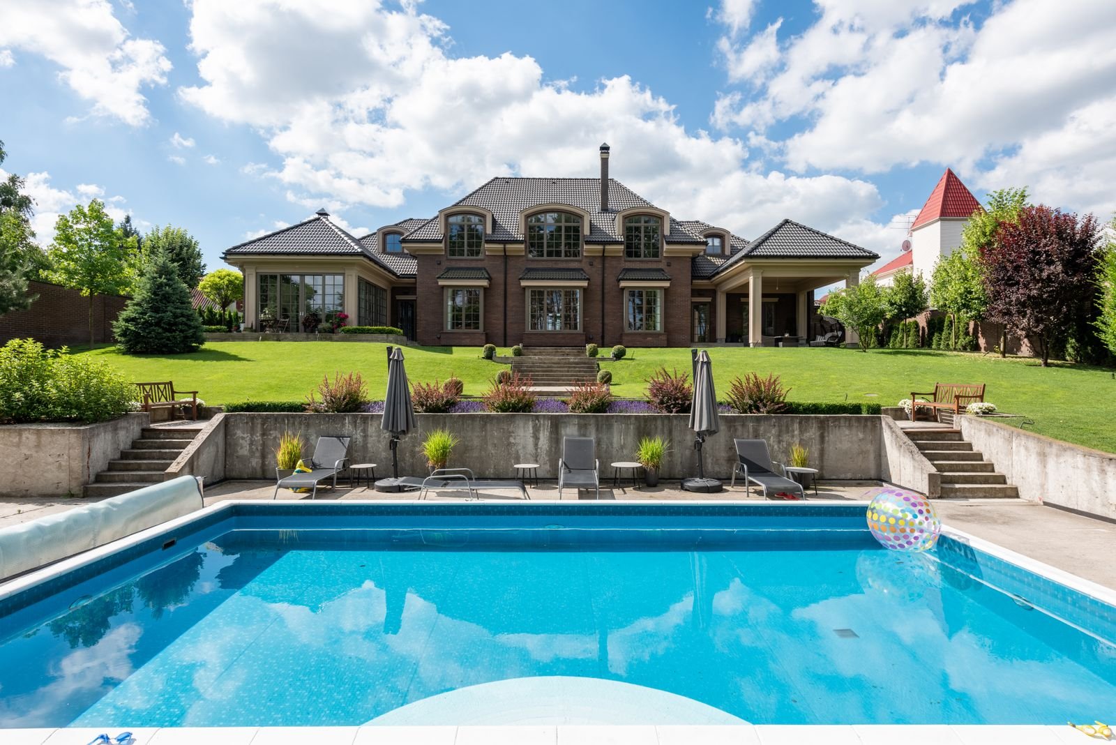 A large, clean backyard pool with a manicured lawn behind a West Valley home