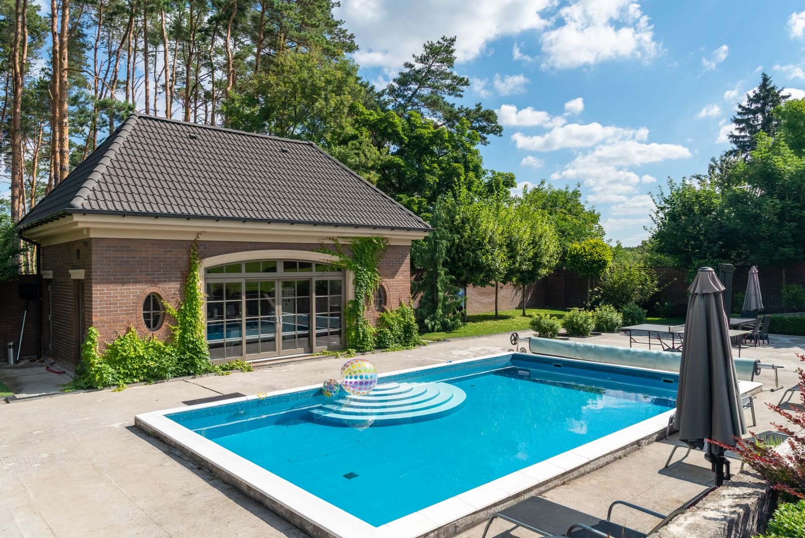 A tidy poolside patio with lounge seating beside clean, well-maintained pool water